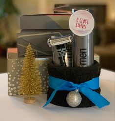 a christmas gift basket is sitting on a table next to a small tree and other items