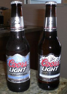 two beer bottles sitting on top of a counter