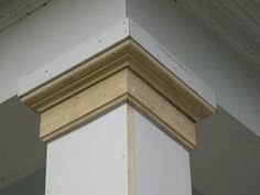 the corner of a building with white paint and wood