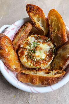 a white bowl filled with bread and cheese