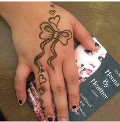 a woman's hand with henna on it and a book in the background