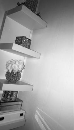 three white shelves with vases and flowers on them