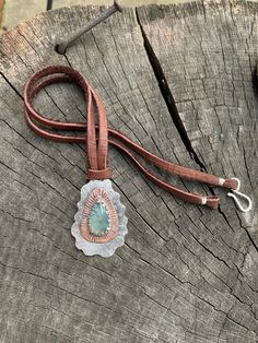 "This unique mixed metals pendant is entirely crafted by hand with primitive metalworking techniques. It features a very high quality aqua chalcedony gemstone with a copper & Sterling silver setting. The copper really makes the gemstone stand out in this piece. This pendant has lots of rustic charm, texture & patina. It is stamped with the Bible verse \"Nahum 1:17\". This would make the perfect inspirational gift for any occasion or as a reminder for oneself to always seek strength throu Artisan Adjustable Turquoise Pendant Necklace, Artisan Hand-tooled Necklace For Gift, Artisan Necklace With Adjustable Patina, Unique Patina Round Pendant Necklace, Southwestern Style Hand Tooled Necklace As Gift, Artisan Teardrop Pendant Necklace, Bohemian Hand Tooled Jewelry For Everyday Use, Hand Tooled Bohemian Jewelry For Everyday, Handmade Artisan Turquoise Teardrop Pendant Necklace