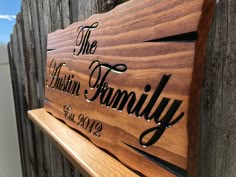 a wooden sign that says the ashton family on it's back side next to a fence