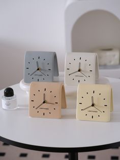 three clocks sitting on top of a white table