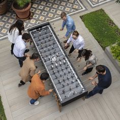 several people standing around a large table with many items on it in the middle of a courtyard