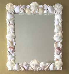 there is a mirror made out of seashells on the wall and in the frame