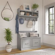 an entryway with a bench, potted plant and mirror