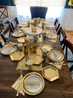 the table is set with gold plates and place settings for two people to sit at