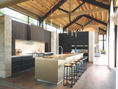 a kitchen with an island and bar stools next to it in front of a large window