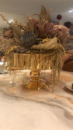 there is a gold vase with feathers on it