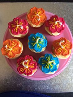 cupcakes decorated with colorful icing on a pink plate