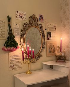 a white desk topped with a mirror and candles