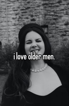 a woman smiling with the words i love older men on her chest and an old brick wall in the background