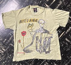 a t - shirt with an image of a skeleton riding a bike and holding a rose