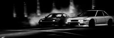 black and white photo of two cars driving in the dark