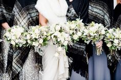 the bride and her bridals are dressed in black, white and grey ponchies