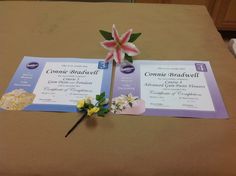 two fake flowers are placed on top of some pamphlets for someone's graduation ceremony