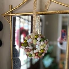 a mirror with a wreath hanging from it's side