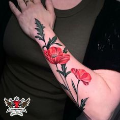 a woman's arm with red flowers on it