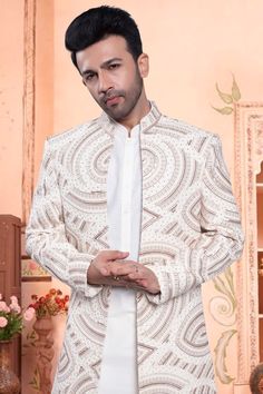 The U2-S404 Sherwani is the perfect combination of traditional and modern. Its open jacket design is adorned with intricate thread, stone, and sequin embroidery for a trendy, yet classic look. Make a statement at any event with this unique and stylish piece. Bandhgala With Naqshi For Reception, Formal Bollywood Nehru Jacket With Chikankari Embroidery, Traditional Outerwear For Receptions And Festivals, Traditional Outerwear For Festivals And Receptions, Traditional Festival Outerwear For Reception, Designer Nehru Jacket With Intricate Embroidery For Reception, Designer Nehru Jacket With Dabka Work For Reception, Traditional Outerwear For Eid Reception, Traditional Embroidered Blazer For Reception