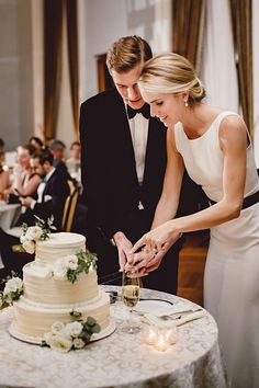 a man and woman cutting into a wedding cake