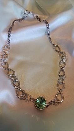 A Dazzling necklace made up of antique pewter links form an interesting design showcasing a peridot crystal at center to add some pizzaz. This infinity chain  of large links is lightweight and finished with a sturdy stainless silver chain...  The center is a peridot green crystal gem encased in a filigree design base.it measures 18 inches. Ready to send to you. And it ships free Metal Link Jewelry For Parties, Silver Metal Chain Necklace As Gift, Silver Metal Chain Necklace For Gift, Silver Chain Link Jewelry For Party, Silver Oval Link Metal Necklace, Nickel-free Silver Infinity Jewelry, Silver Chunky Chain Round Jewelry, Silver Jewelry With Chunky Chain, Sterling Silver Jewelry With Chunky Chain