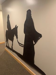 the shadow of a man on a horse is painted on a wall in an office