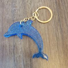 a blue dolphin keychain sitting on top of a wooden table