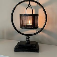 a candle is lit in the center of a metal ring on top of a table