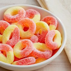 a bowl filled with sugar coated donuts on top of a table