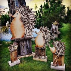 three hedgehog sculptures sitting on top of wooden stumps