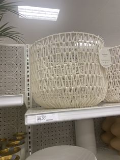 a white basket sitting on top of a shelf in a store