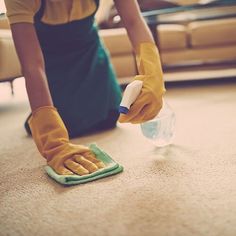 a woman cleaning the floor with a micro mop and cloth on her hand while wearing yellow rubber gloves