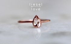 "A rare and special gem for a rare and special wearer! Our 14K \"Rarity\" ring features a pear shaped morganite stone, set in a bezel. A perfect alternative engagement ring for the bride that's thinking pink! - Pear morganite measures 6mm by 4mm, high quality, clear tone - Choose between 14K yellow, white or rose gold - Round band measures 1mm in width Processing times - Current processing time is 1 - 3 weeks. Each Item is handmade to order with love and care! In Stock Items - Contact Liesel Lov Pear-shaped Vs Clarity Jewelry Gift, Pear Shaped Bezel Setting Wedding Rings, Pear-shaped Bezel Set Wedding Ring, Pear Shaped Ring With Bezel Setting As Gift, Pear-shaped Bezel Setting Ring As Gift, Pear-shaped Ring With Bezel Setting For Gift, Gift Pear Shaped Ring With Rose Cut Diamonds, Pear Shaped Rose Cut Diamond Ring For Gift, Pear-shaped Rose Cut Diamond Ring For Gift