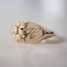 This vintage-inspired floral ring is a row of dainty flowers wrapped around your fingers. Handmade and polished, it is available in solid 8K and 14K gold. This item is engravable with text or monogram of your choice at no extra cost. The initals are engraved onto the ring and embedded in the 3D model for a flawless embossed finish. It is also possible to add a diamond or birthstone or diamond to this ring at an additional fee. Please inquire for details. A few notes about our gold: - Though we d Signet Engagement Rings, Big Diamond Engagement Rings, Ring Size Chart, Couple Ring Design, Dainty Flowers, Diamond Signet Ring, Engraved Ring, Yellow Gold Jewelry, Gold Monogram