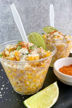 two bowls filled with mexican food next to limes and seasonings on a table