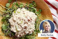 a plate filled with salad on top of a red and white striped table cloth next to a photo of dolly parton