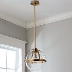 a light fixture hanging from the ceiling in a room with gray walls and white trim