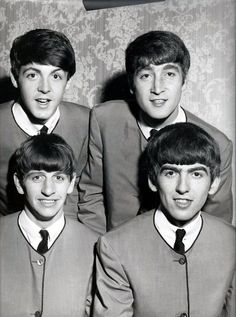 the beatles are posing for a photo in their suits and ties, with one man's head tilted to the side