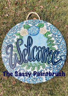 a blue and white sign that says welcome the sassy paintbrushes on it