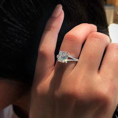 a woman's hand with a diamond ring on it