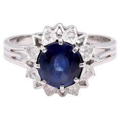 Center Stone: Sapphire Certificate: GIA  #5202979107 Cut: Oval Weight: 2.21 Carat Color: Blue Origin: Madagascar Treatments: No Indications Of Heating Accent Stone: 8 Diamonds Cut: Single Weight: Approximately 0.2 Carats Color: G Clarity: SI Metal: 18K White Gold Era: Mid-Century Circa: 1950s Hallmarks: Makers Marks Size: 8.5 and can be resized Gram weight: 6.28 This exquisite mid-century ring from the 1950s features a stunning GIA-certified 2.21-carat oval-cut sapphire at its center. The sapphi Edwardian Engagement Ring, Sapphire Cocktail Ring, Contemporary Engagement Rings, Blue Origin, Platinum Diamond Rings, Modern Engagement Rings, Blue Sapphire Diamond, Modern Ring, 18k Yellow Gold Ring