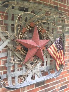 an american flag hanging on the side of a brick building with a star and wreath