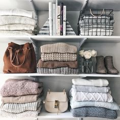 the shelves are filled with folded towels and purses, books, and other items