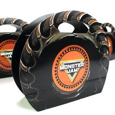 three black and orange coasters with monster jam logo on the front one has an orange ring around it's center