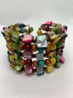 Mother of Pearl Rainbow Cuff Dyed Mother Of Pearl Beads Wood and Glass Beads Pride Colors Festival Bracelet This Is A Used Item In Condition Bohemian Multicolor Round Beads Cuff Bracelet, Bohemian Beaded Pearl Bangle Bracelet, Bohemian Multicolor Beaded Cuff Bracelet, Bohemian Multicolor Bracelets With Polished Beads, Bohemian Beaded Cuff Bracelet For Beach, Handmade Multicolor Pearl Bracelet For Beach, Multicolor Handmade Pearl Bracelet For Beach, Handmade Multicolor Bohemian Pearl Bracelet, Artisan Multicolor Wooden Beaded Bracelets