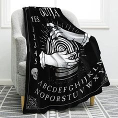 a black and white blanket with an image of a hand holding a clock on it