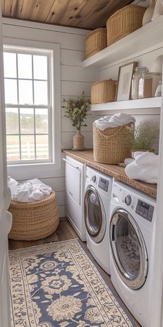 a washer and dryer sitting in a room next to a window with baskets on it