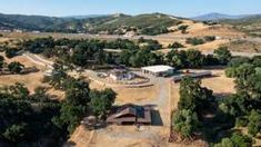 an aerial view of a farm in the hills